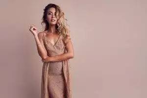 gorgeous woman with blonde wavy hair wearing elegant beige dress