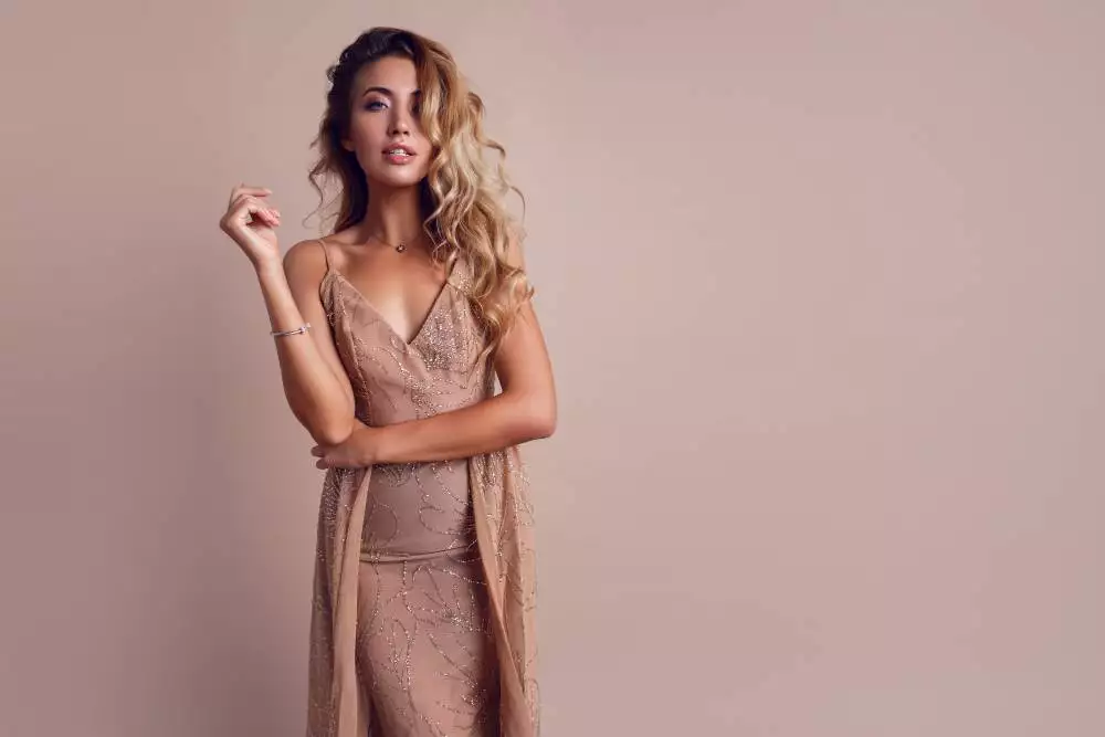 gorgeous woman with blonde wavy hair wearing elegant beige dress