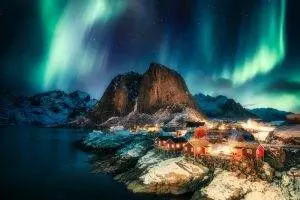 aurora borealis northern lights mountain with fishing village coastline hamnoy lofoten islands norway