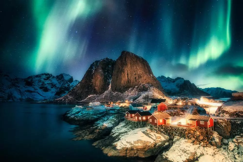 aurora borealis northern lights mountain with fishing village coastline hamnoy lofoten islands norway