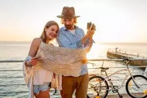 happy couple traveling summer bicycles looking map taking photos camera