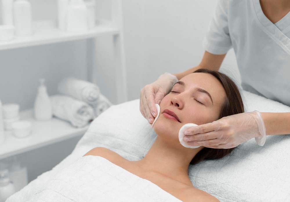 beautician with female client salon face care routine