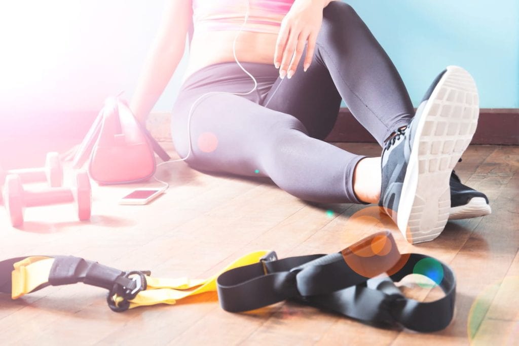 female fitness resting relaxing after workout woman sitting down wood floor sport fitness healthy lifestyle concept
